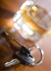 An alcoholic beverage on a table next to some car keys.