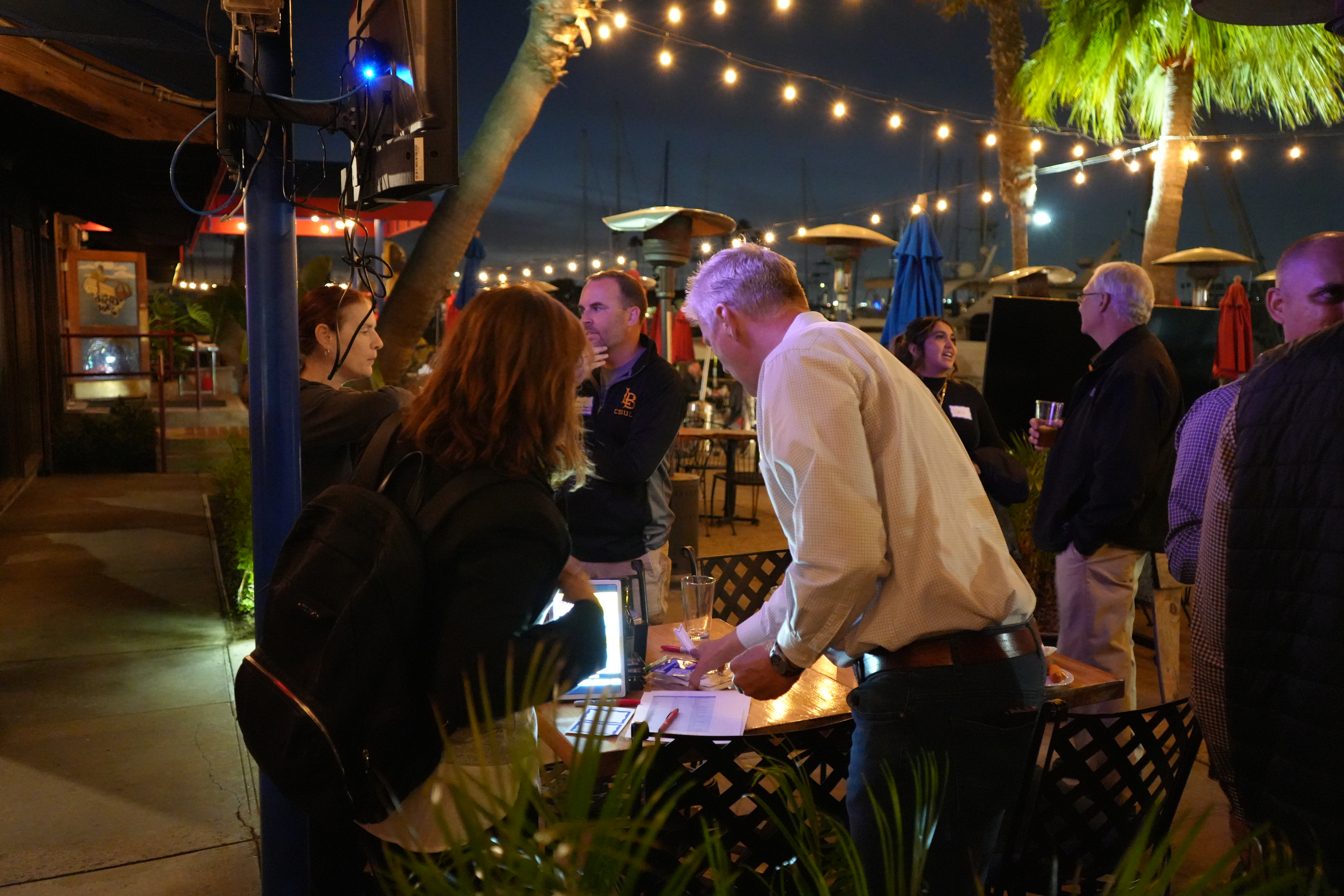 Image of multiple attendees checking-in at the November mixer at the Crab Pot. 