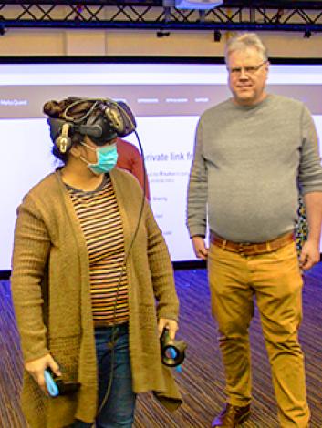 Stephen Adams poses with students using VR technology