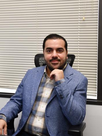 Amin Rezaei poses at desk