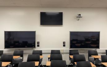 three monitors on back of classroom wall