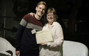 Graduate student Kevin Travis poses with President Jane Close Conoley, as he accepts his Public Knowledge Media Training certificate of completion.