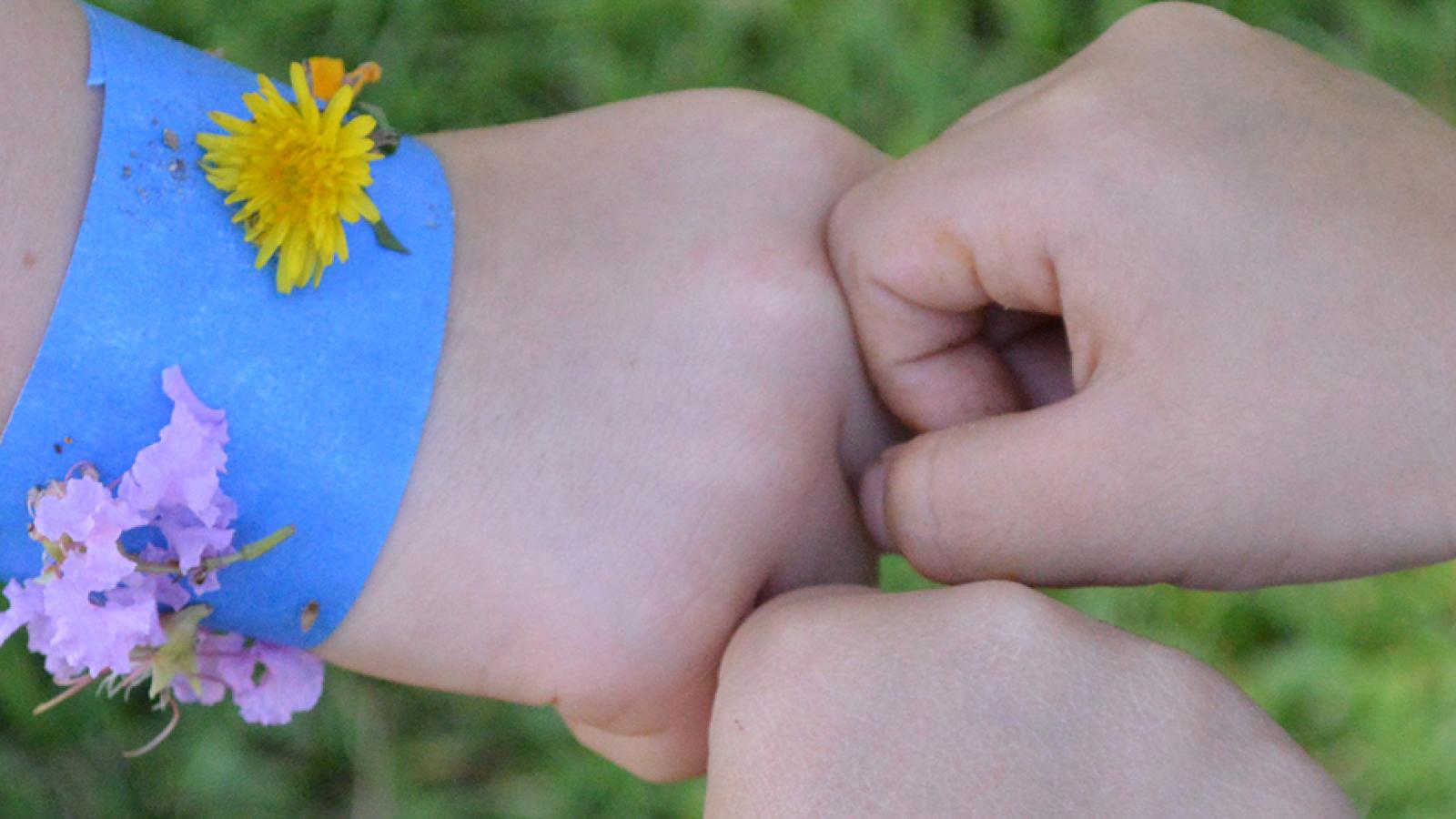 children showing off bracelets made from flowers