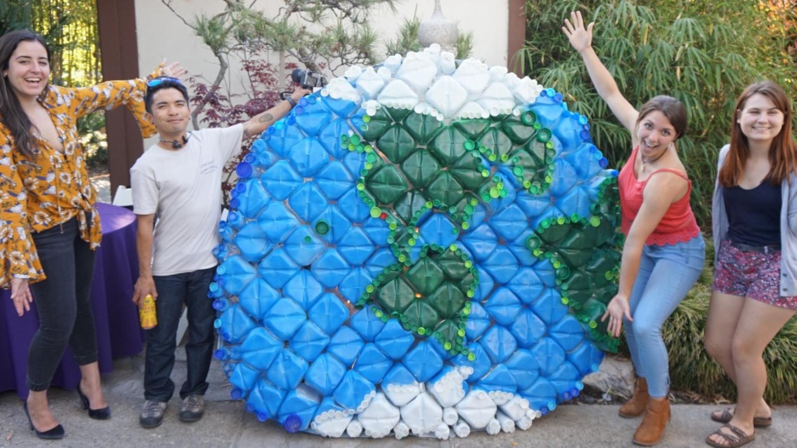 Students presenting globe made from recycled milk jugs at Green Generation Mixer