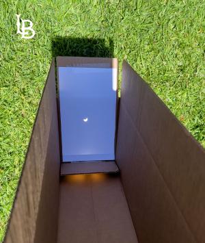 Partial solar eclipse as viewed through hole in a cardboard box