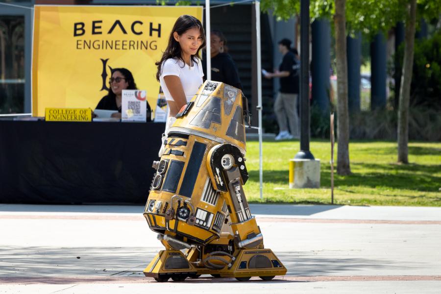 Student walking by yellow robot