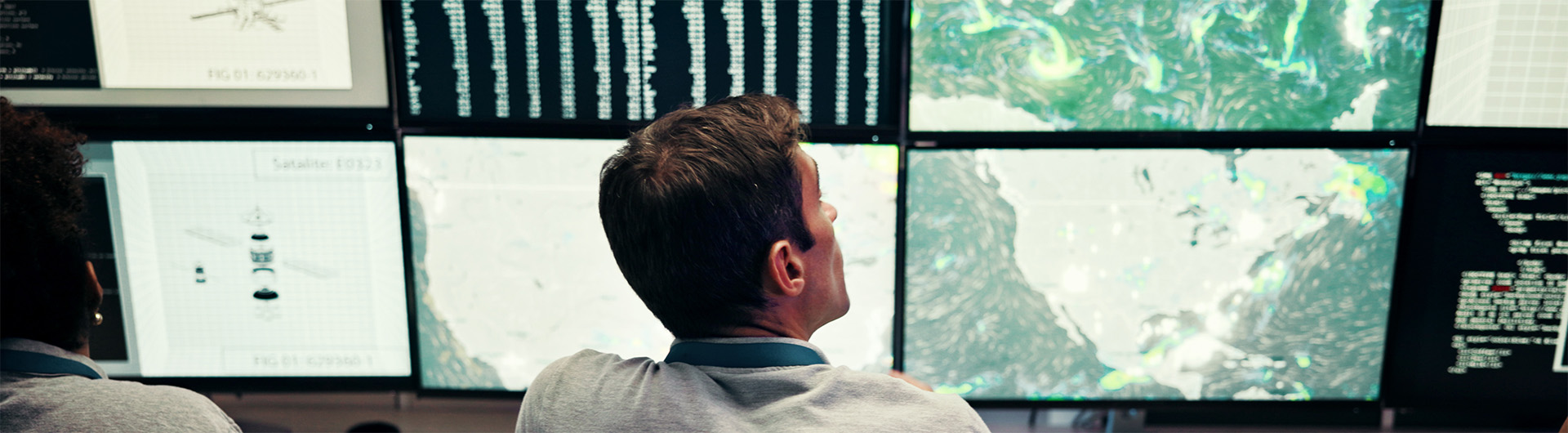 scientists monitoring multiple screens that contain weather data