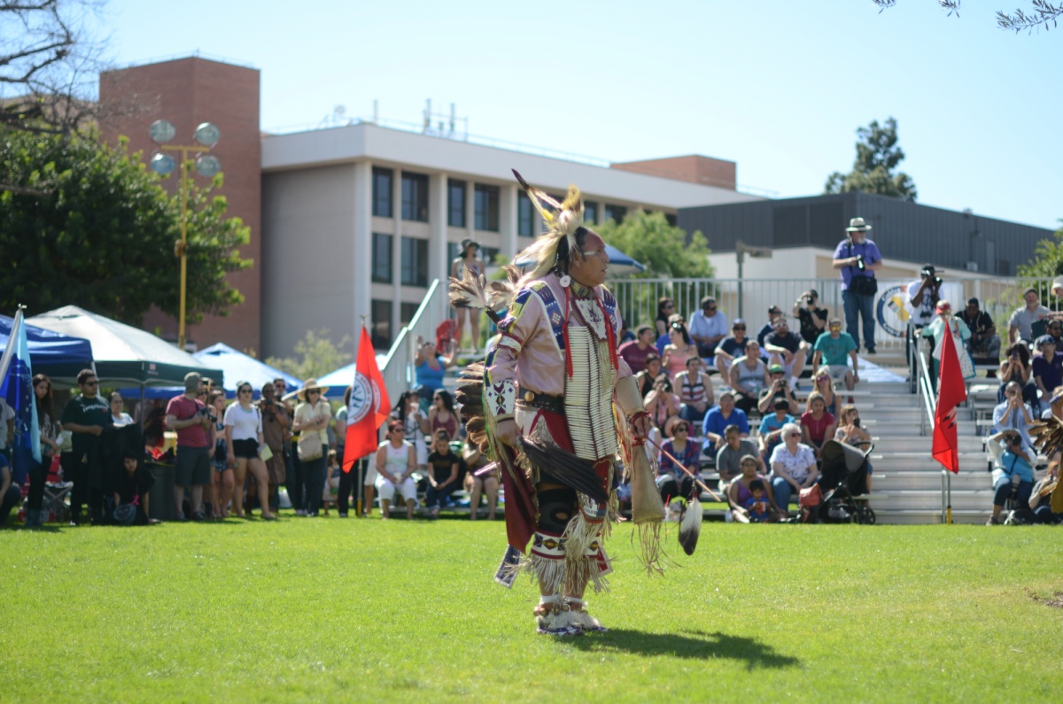 A Native American performer mid-dance 