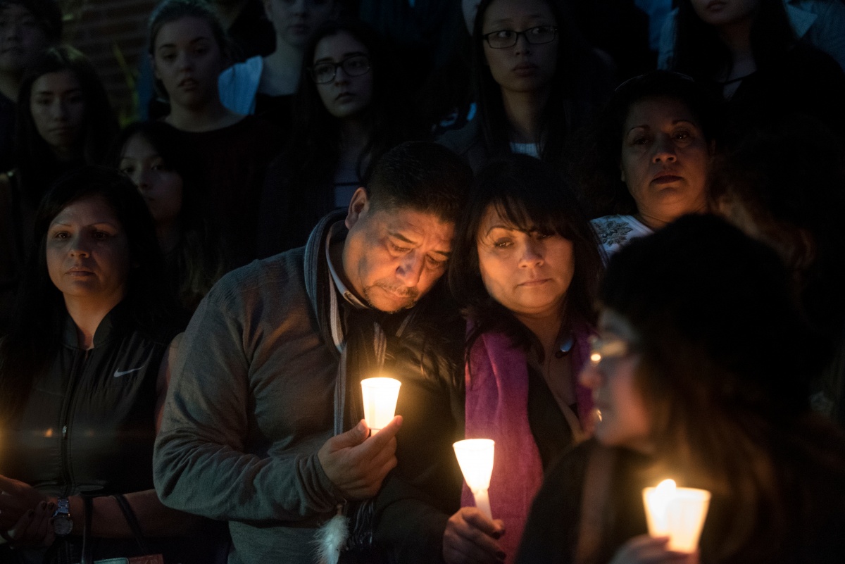 Nohemi Gonzalez's parents hold candles in her honor.