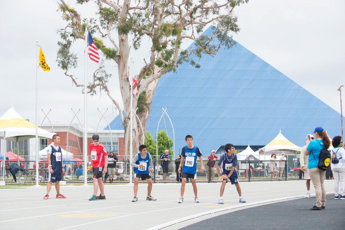 Track & Field competitors with the Walter Pyramid in the bac