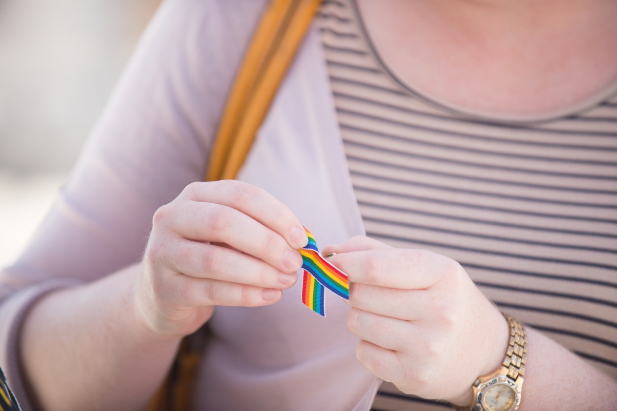 A rainbow ribbon on the chest of an attendee