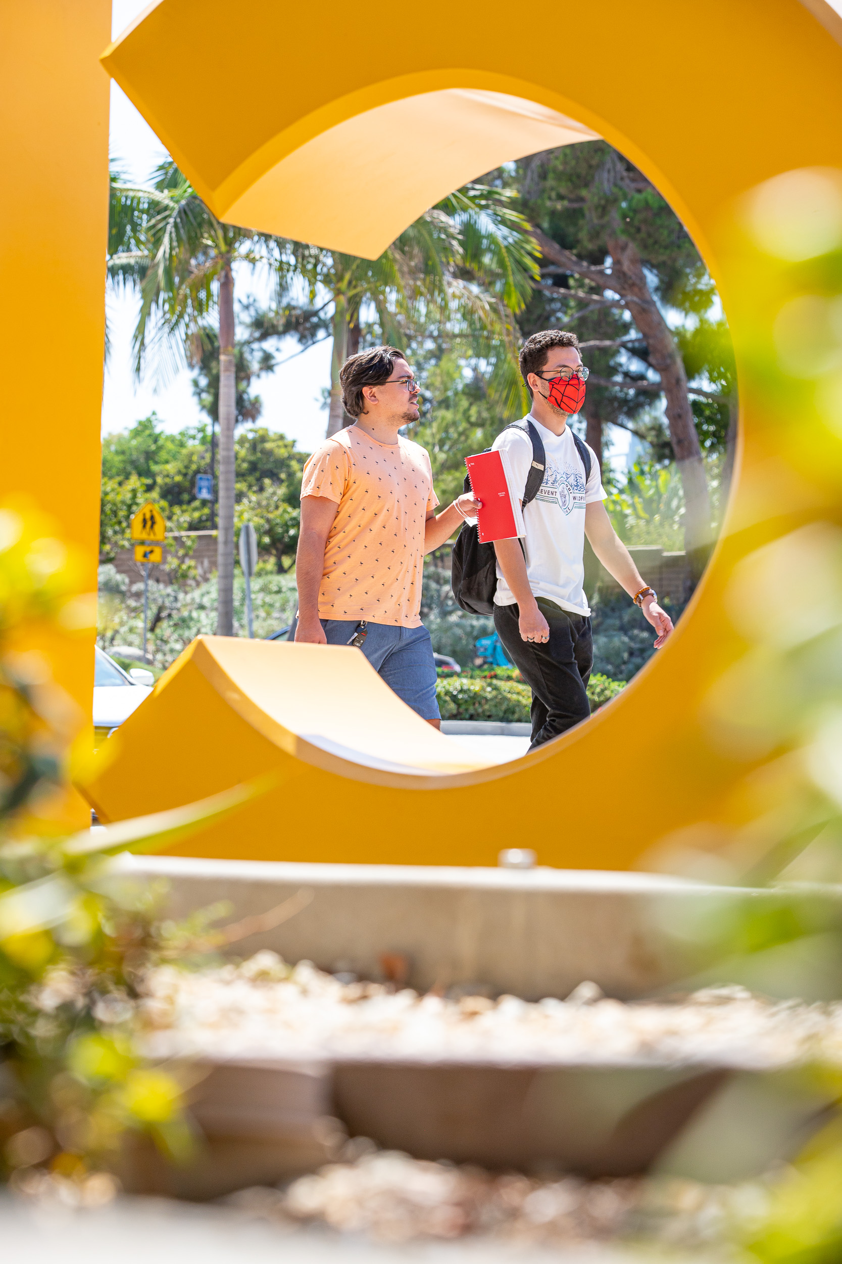 Students walk by the GO BEACH letters