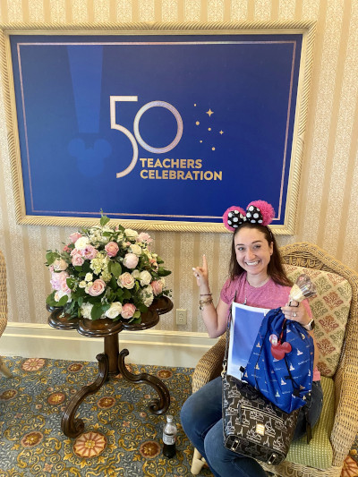 Rachel Posteraro in front of 50 Teachers Celebration sign