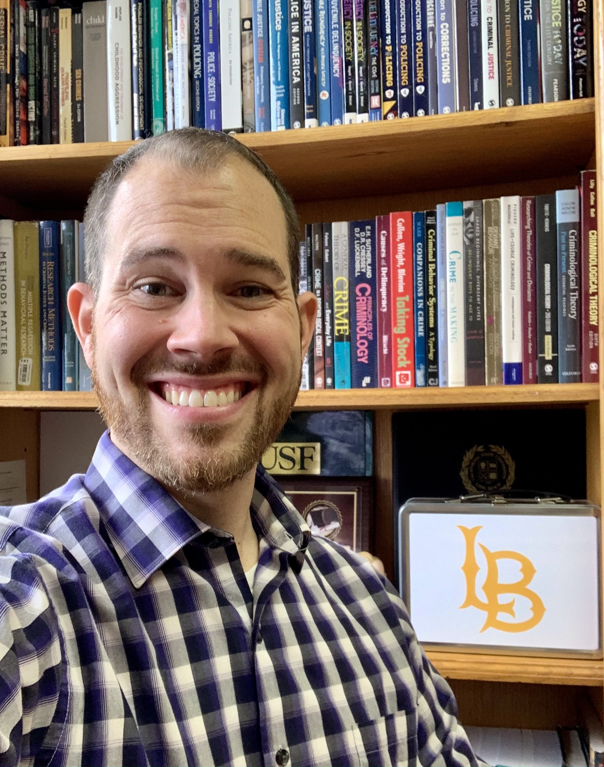 Dr. Perez smiling in front of bookcase