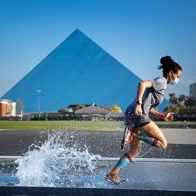 Runner creates splash running in Steeple chase with Pyramid in background