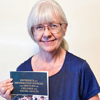 Professor Lesley Farner holds book