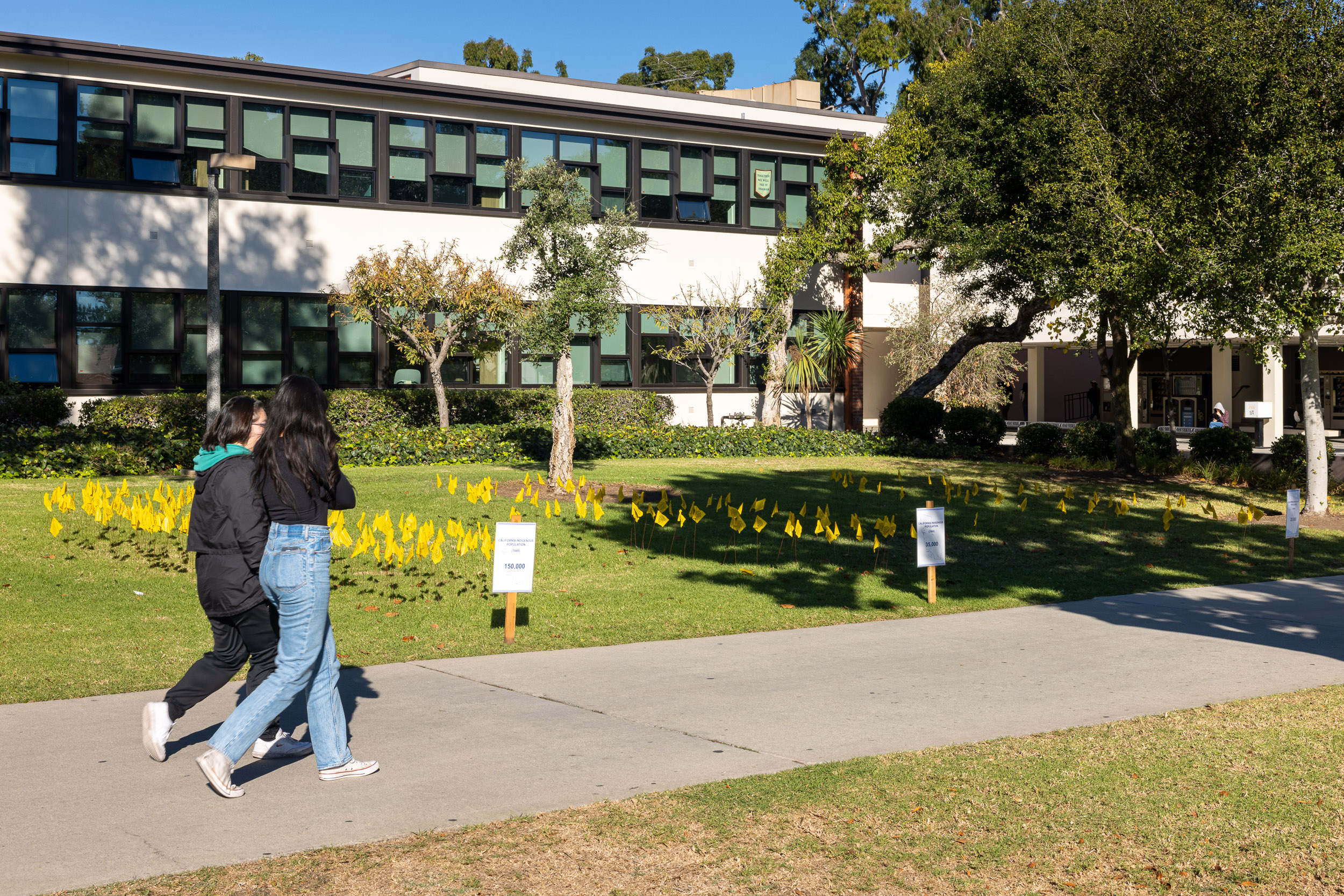 Students walking by flag installation