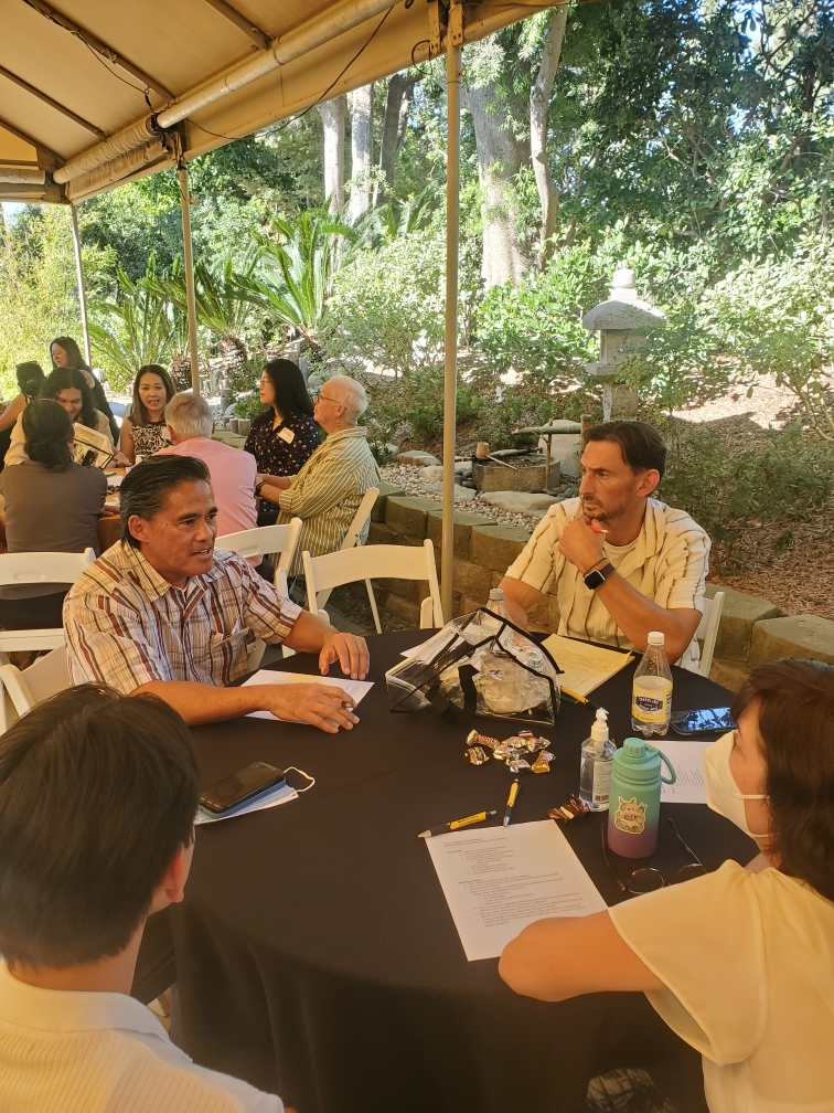 A group of people talking at a round table