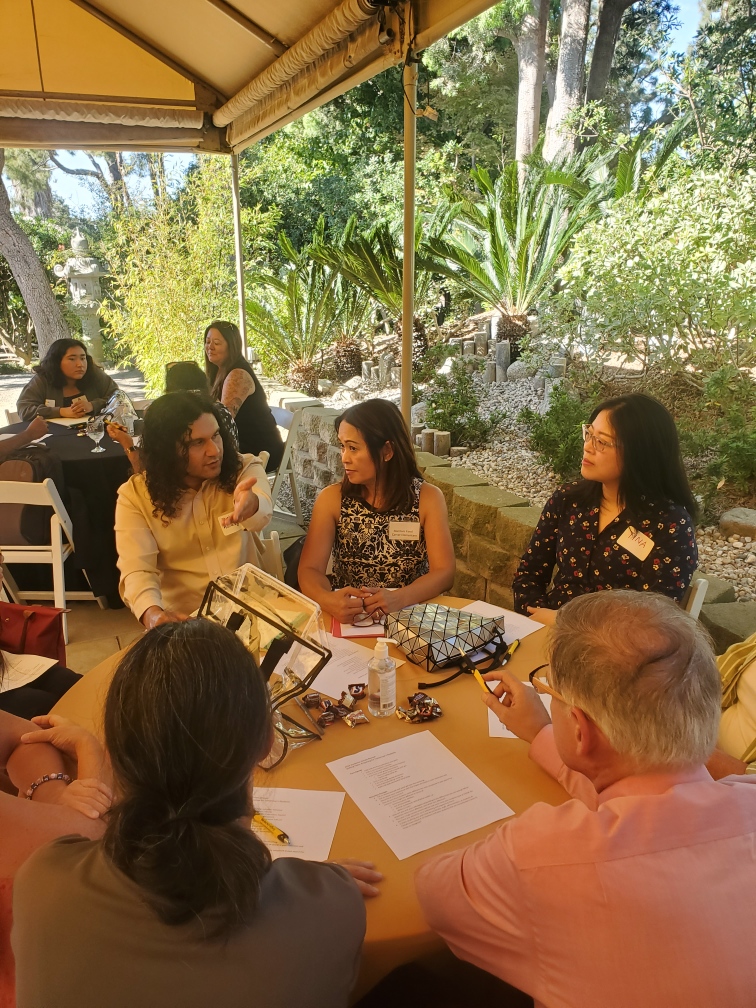 A group of people talking at a round table