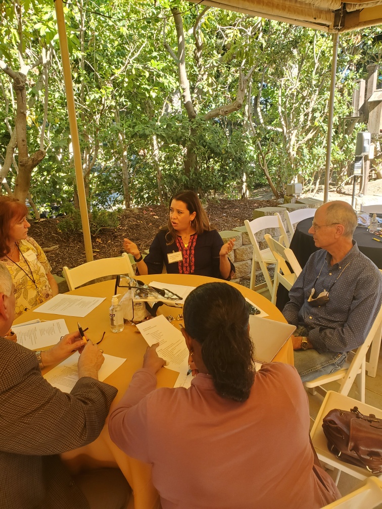 A group of people talking at a round table