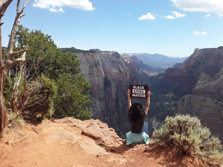 Duarte shows solidarity with the Black Lives Matter movement by lifting a BLM poster above Zion National Park shortly after a Minneapolis police officer was convicted of murder in the death of George Floyd.