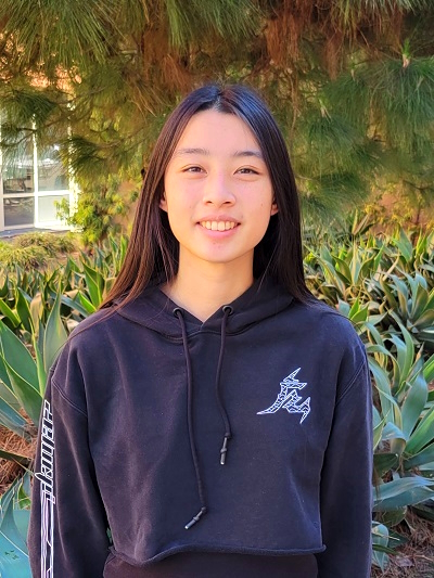 Michelli Chai standing in front of greenery