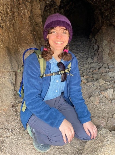 Brynn Sablan kneeling in a cave