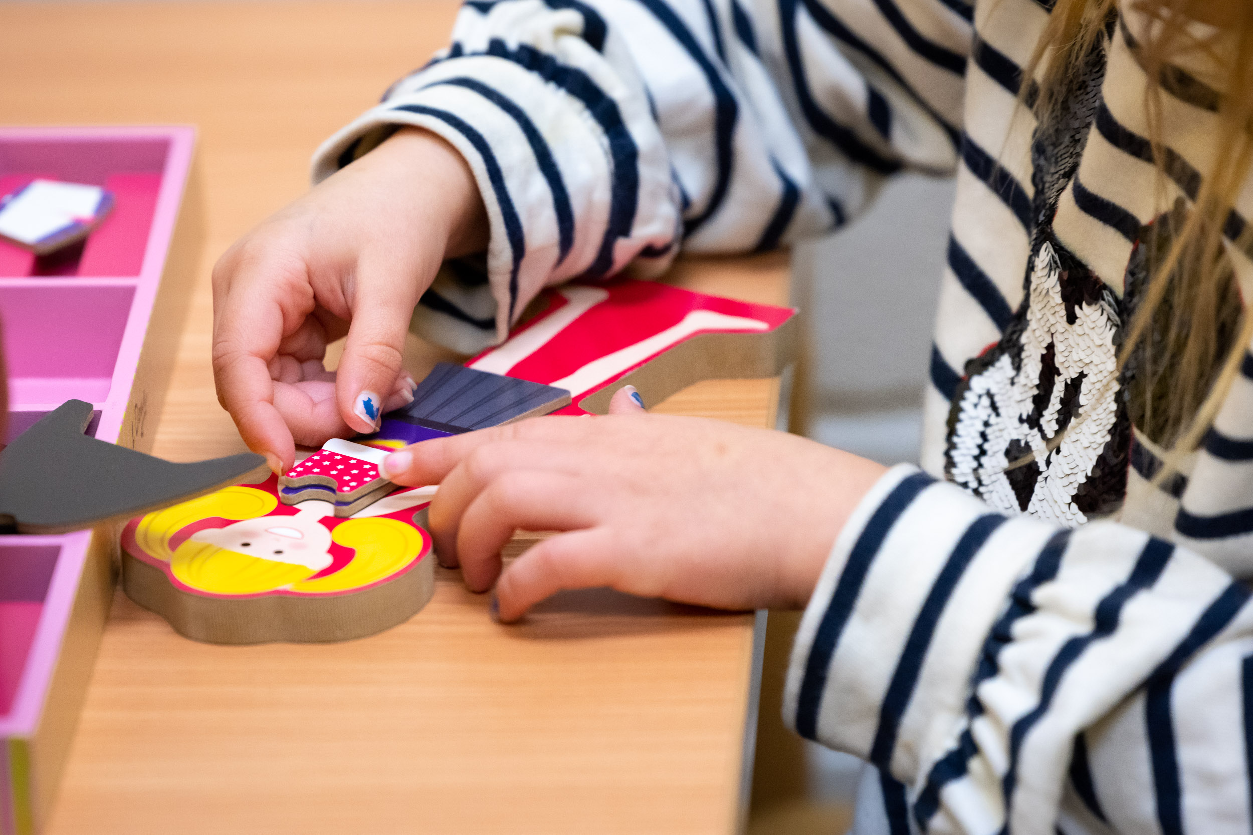 Child playing with wooden paper doll