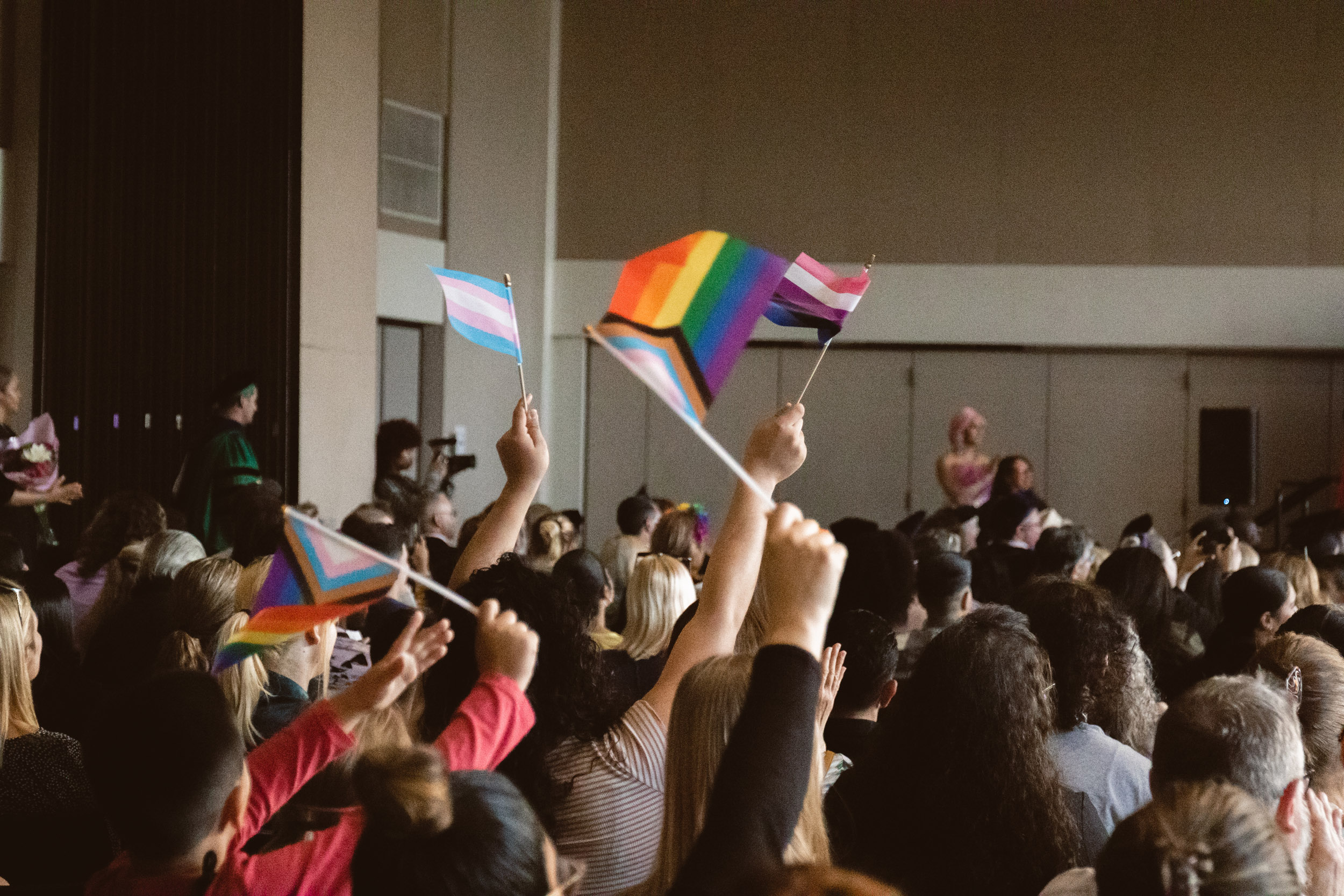 Graduates wave rainbow flags