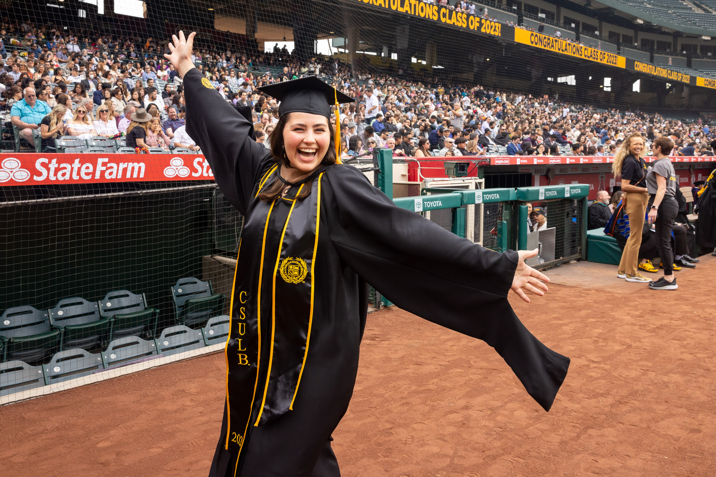 Grad walking past dugout celebrates