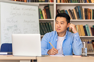 instructor looking at laptop on desk