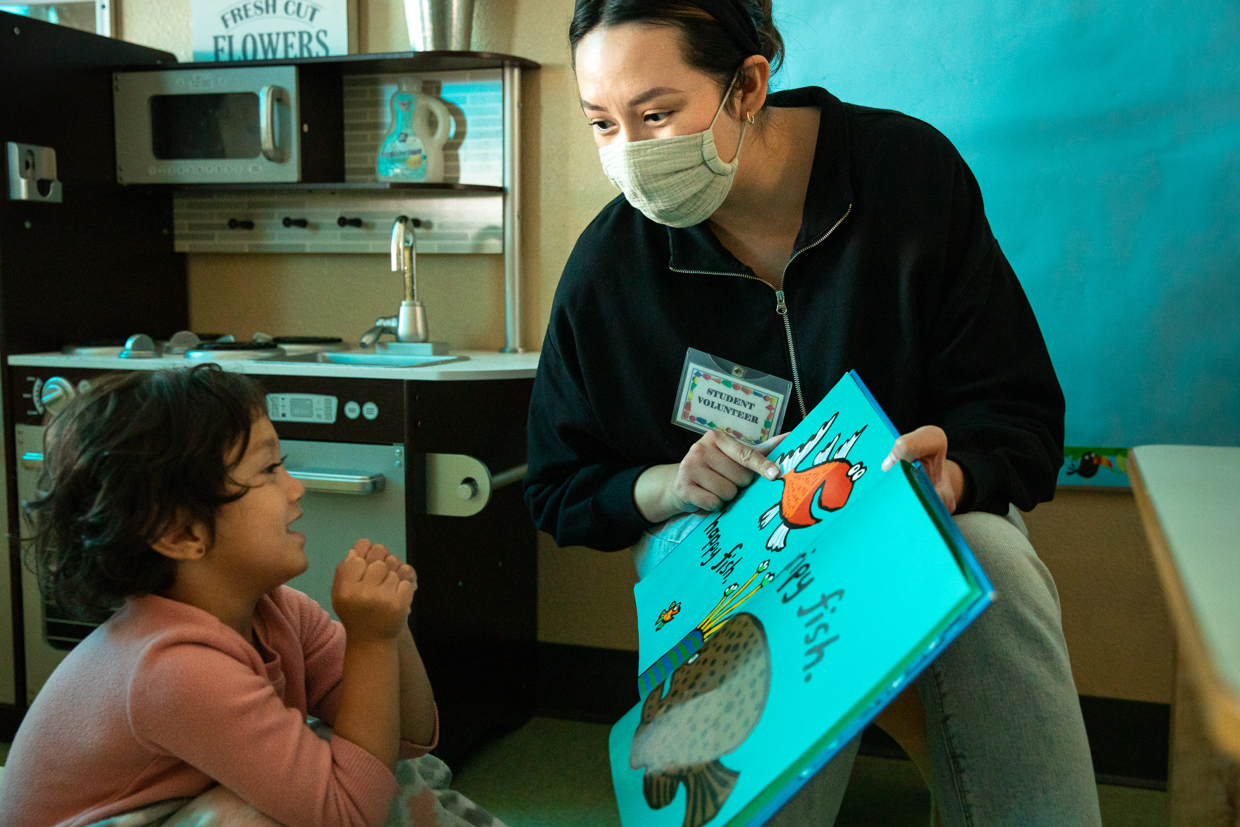 Teacher showing young student a book