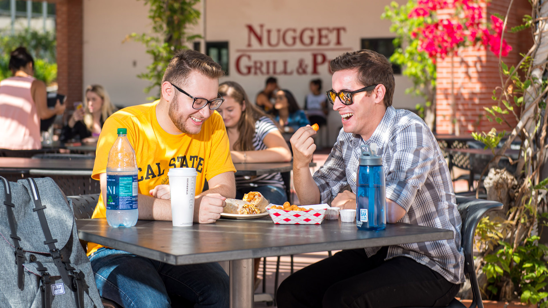 Students, staff and faculty eat on the outdoor patio next to the Nugget Grill & Pub. 