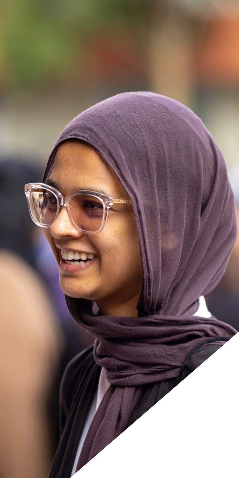 A female student looking off camera smiles. 