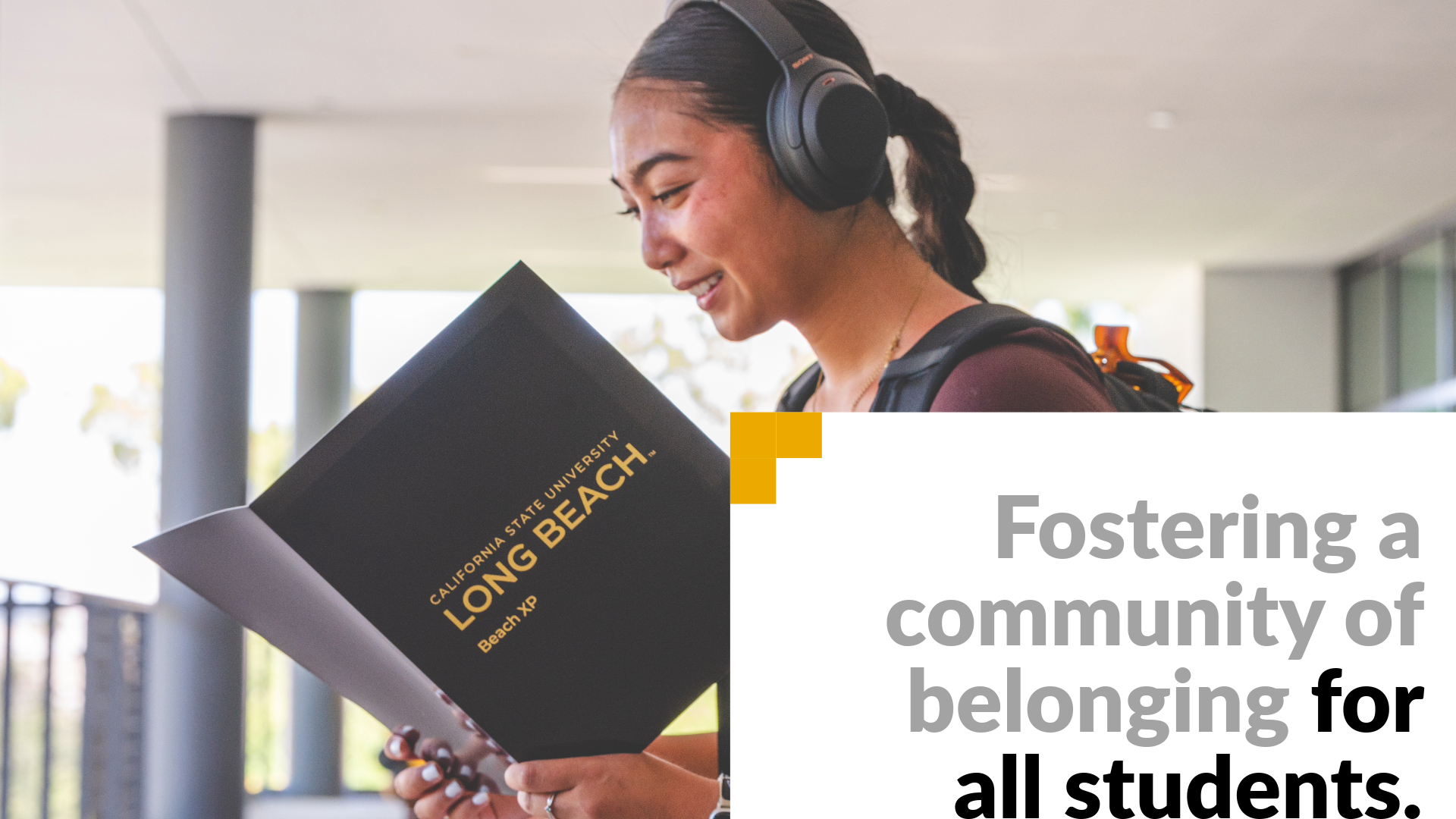 Fostering a community of belonging for all students. Image shows a student wearing headphones looking over a Beach XP folder. 