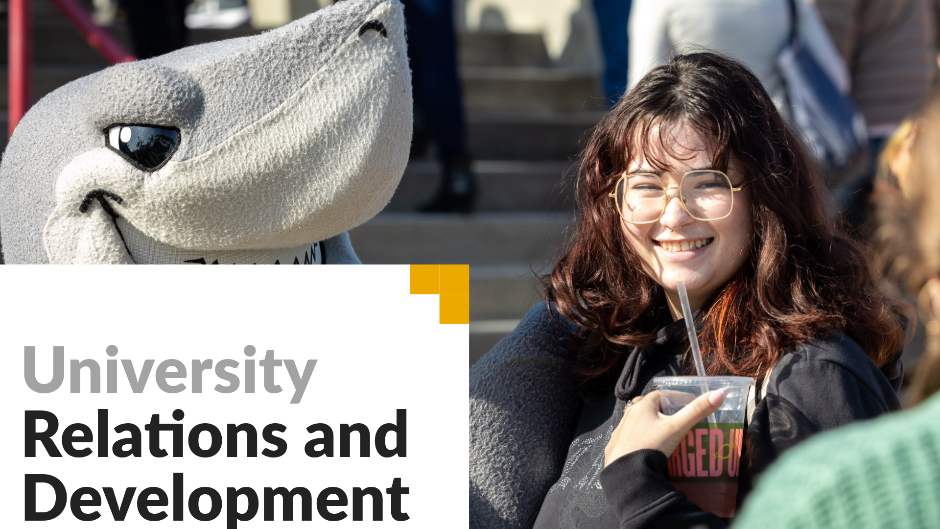 University Relations and Development. Image shows a student smiling next to Elbee. 