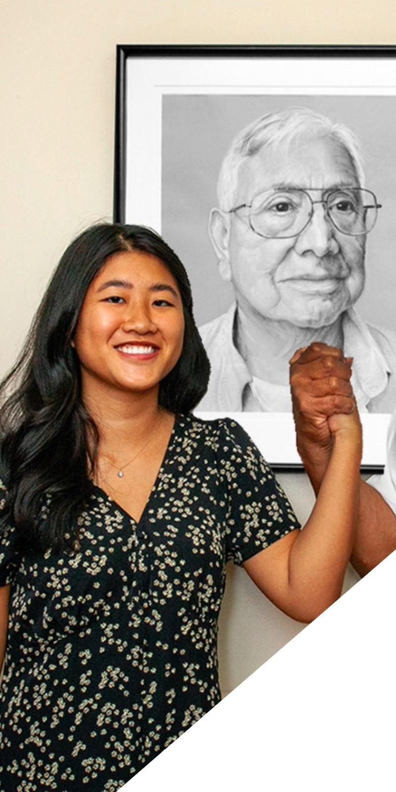 A student smiles next to her veteran portrait. 