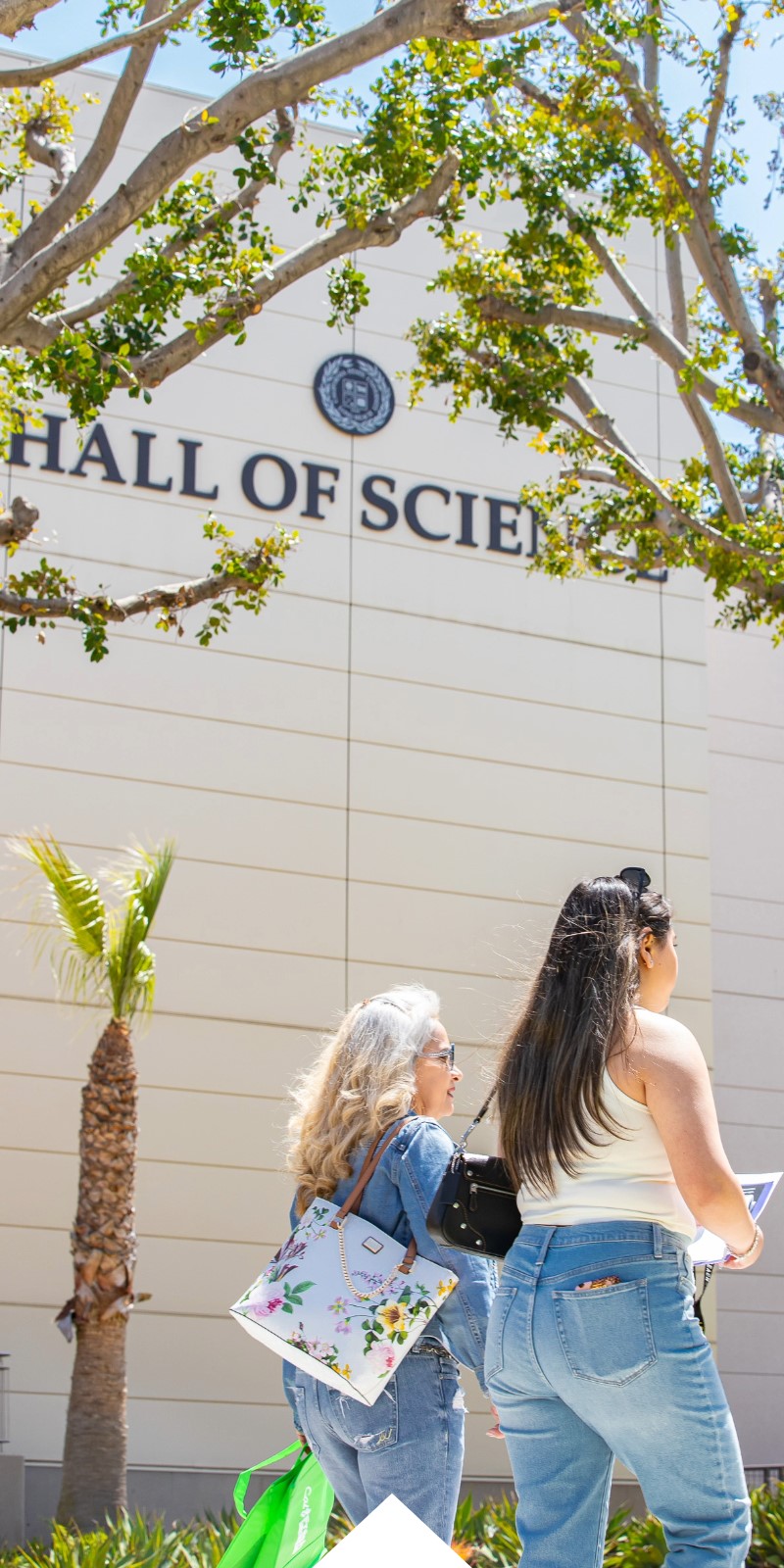 Two women walk past the Hall of Sciences.