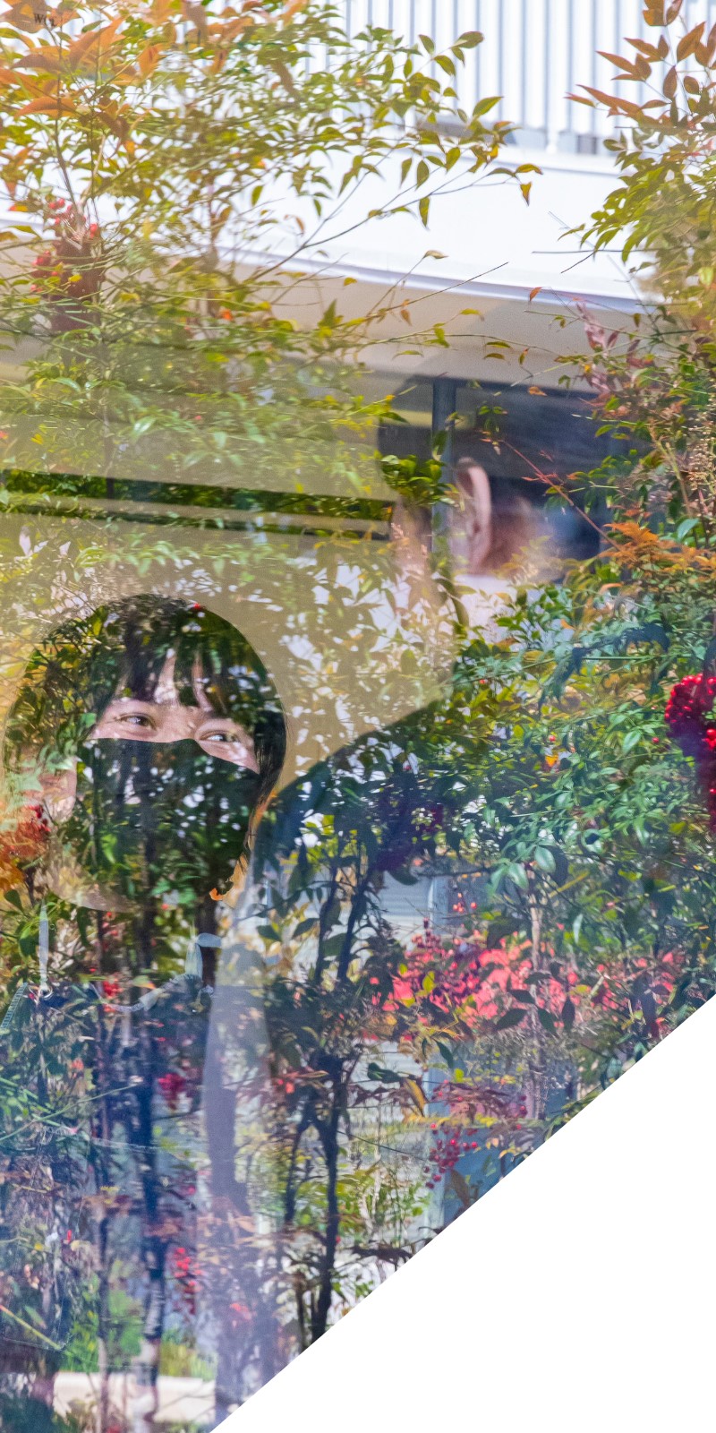 Two people are seen through a window talking. 