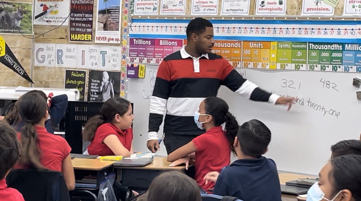 Teacher Aaron Carter shows students how to solve a problem