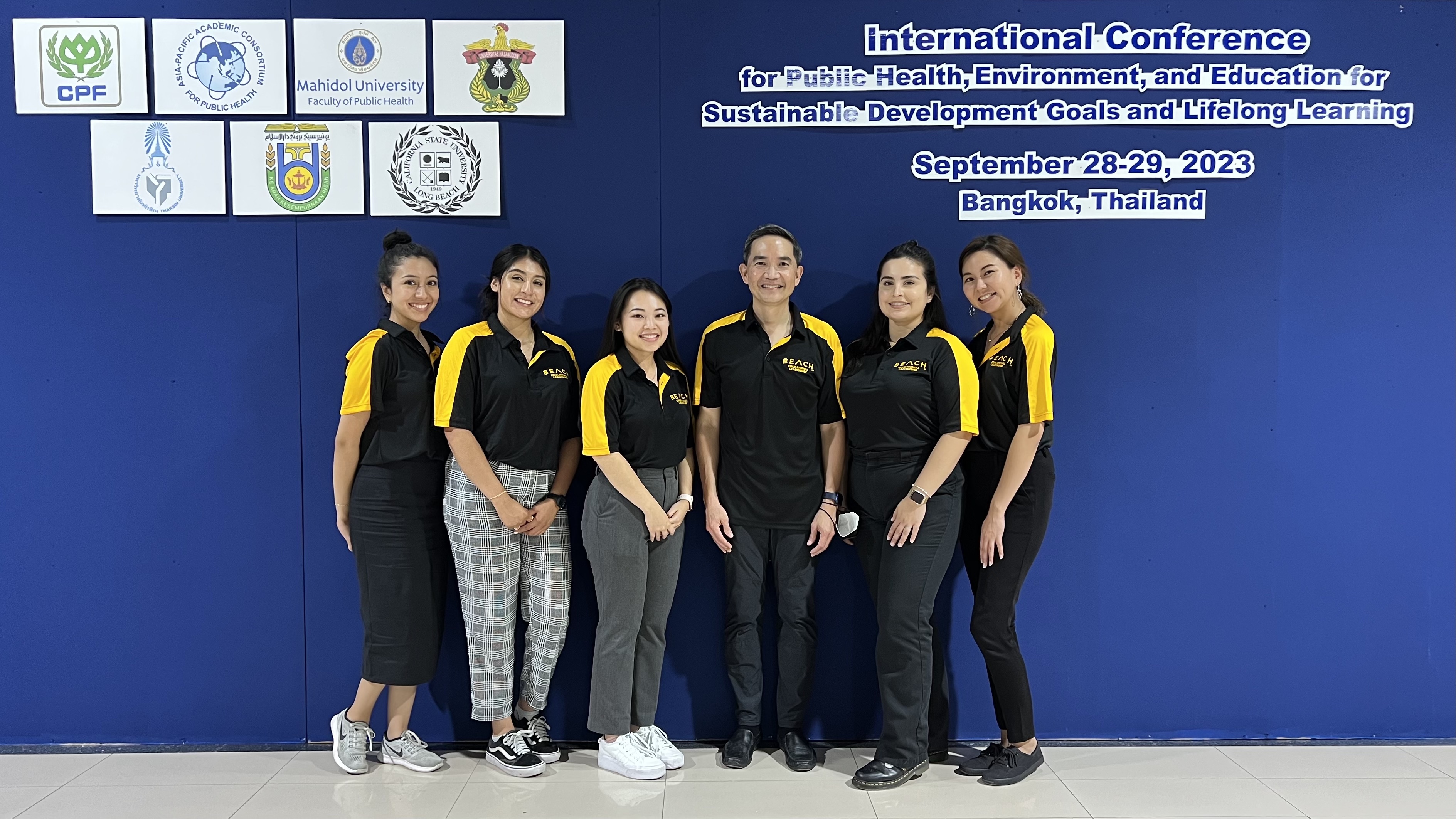 A group of students pose for a picture at a conference.