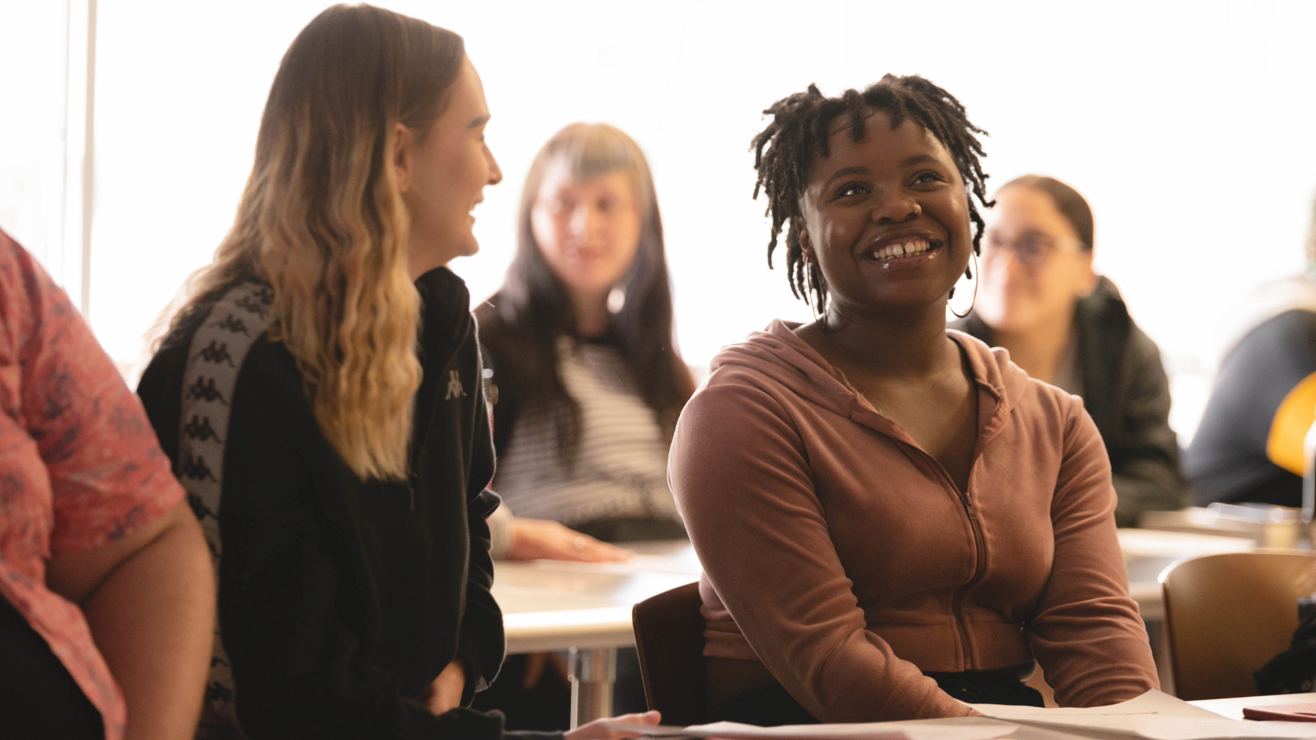 Two students are sitting and smiling.