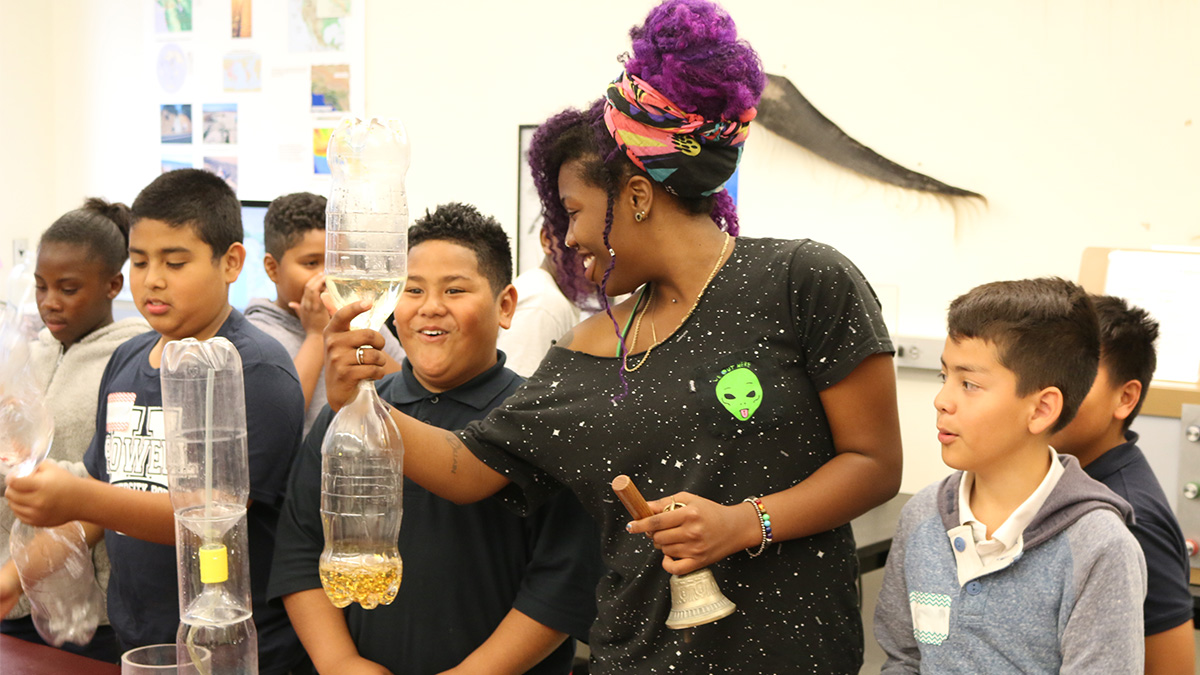 teacher demonstrating a cyclone bottle