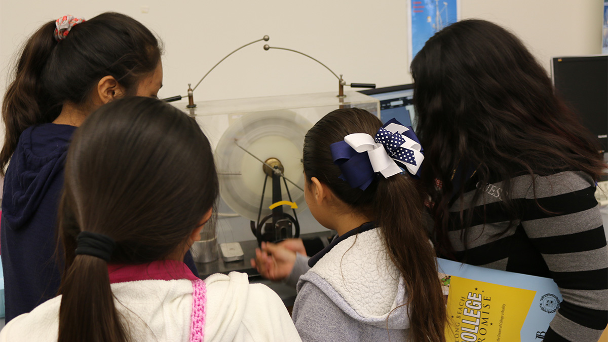 kids turning a crank and generating an electric spark