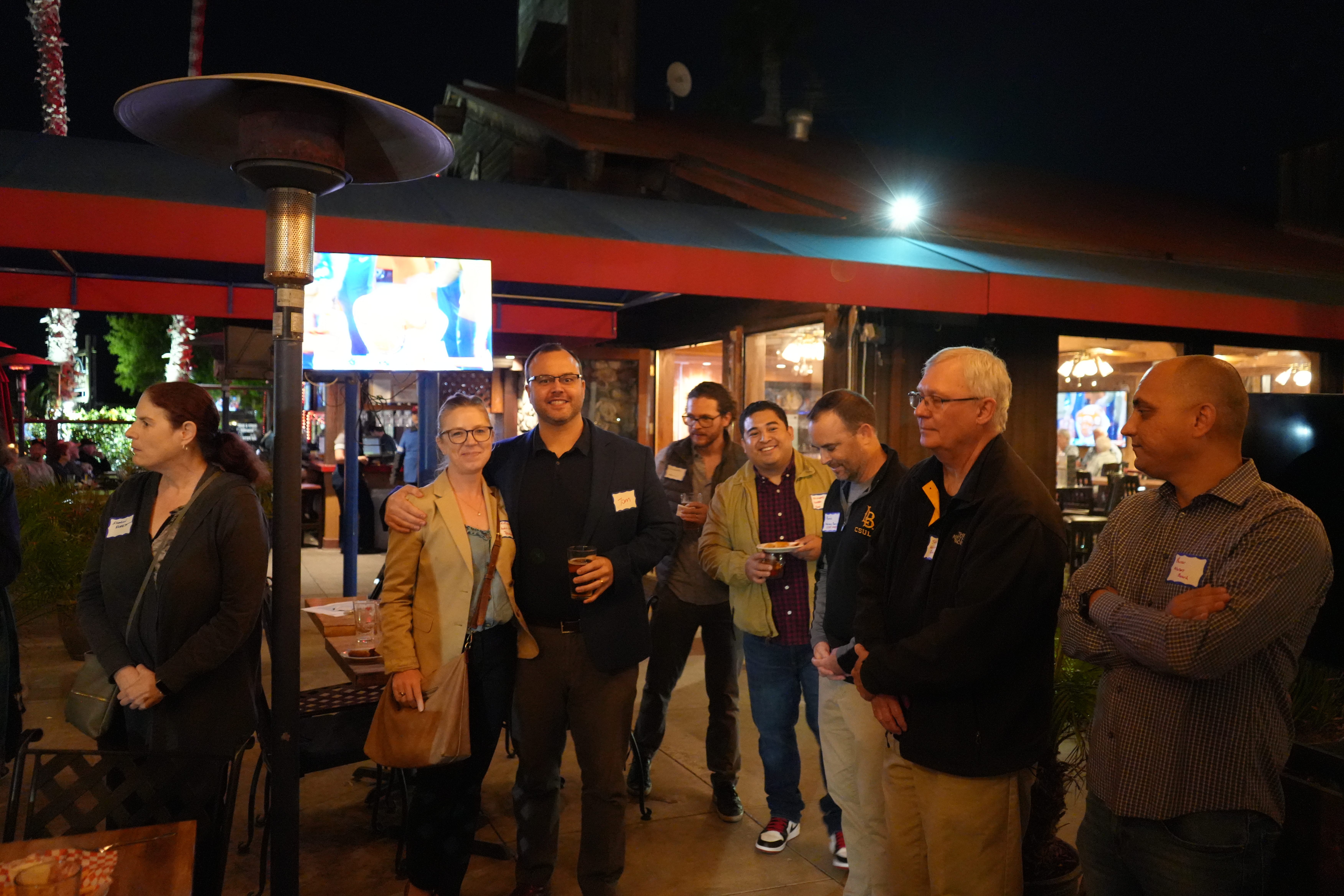 Image of multiple attendees talking and smiling at the November mixer at the Crab Pot. 