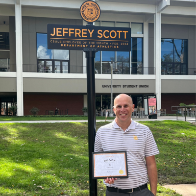 Assistant Athletic Director Jeffrey Scott Jeffrey Scott pictured next to Employee of the Month sign