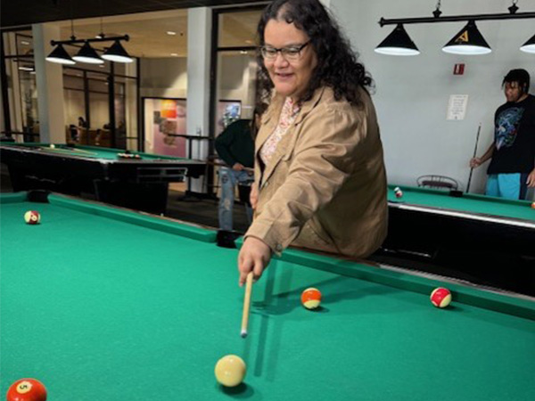 student lining up a pool shot