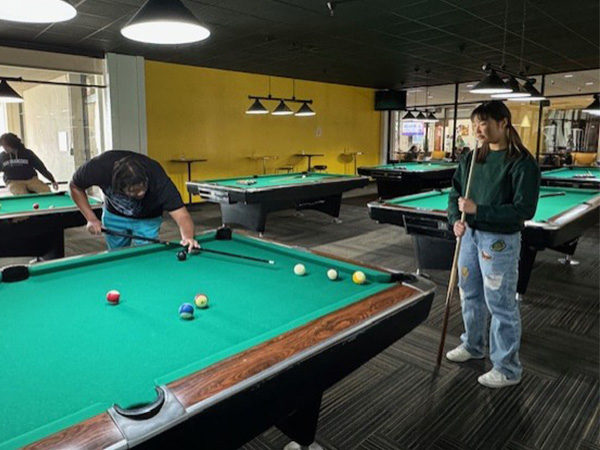 student lining up a pool shot