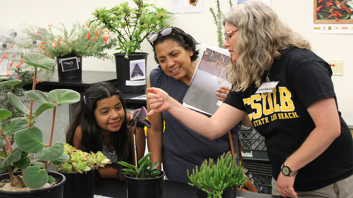 teacher pointing out features of an orchid to visitors