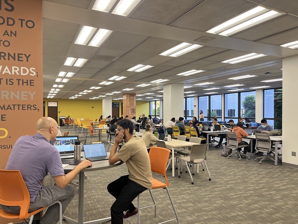 Image of students writing and studying in the library